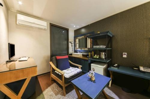 Dieses kleine Zimmer verfügt über einen Schreibtisch und einen Tisch mit einem Stuhl. in der Unterkunft Jeonju Stay Hotel in Jeonju