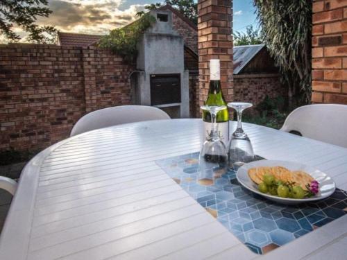 una mesa con un plato de comida y una botella de vino en Dew Drop Inn, en Nelspruit