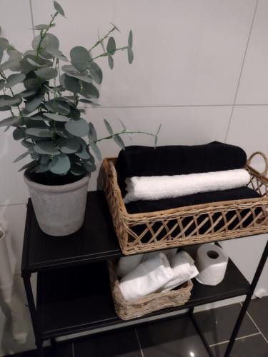a bathroom with two baskets of towels and a potted plant at Light home apartment Alesund with free parking in Ålesund