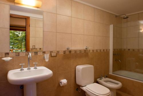 W łazience znajduje się umywalka, toaleta i prysznic. w obiekcie Hosteria La Camila w mieście Villa La Angostura
