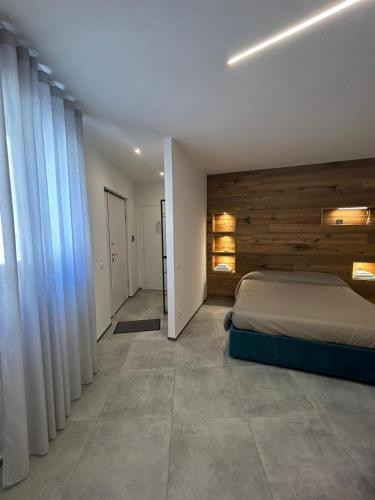 een slaapkamer met een bed met een houten muur bij J. Suite in Castel di Sangro