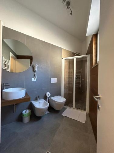 een badkamer met 2 toiletten, een wastafel en een douche bij J. Suite in Castel di Sangro