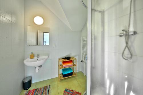 a white bathroom with a sink and a shower at Penzion Kairos in Klokočí