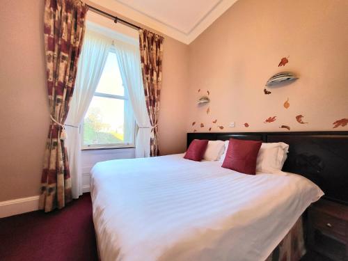 a bedroom with a large bed with a window at Straven Guesthouse in Edinburgh