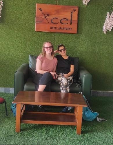 two women sitting on a couch in a room at Xcel Luxury Hotel Apartments-Home Living Redefined in Mysore