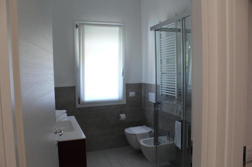 a bathroom with a toilet and a sink and a window at Residenza Sante in Lazise