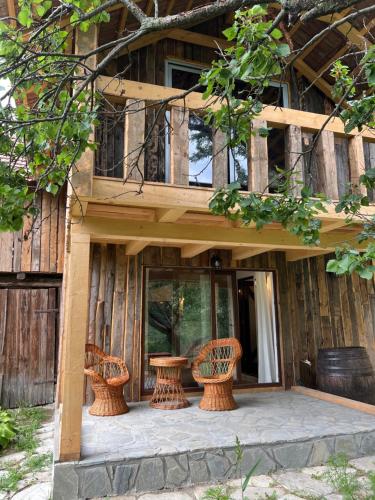 a building with three wicker chairs in front of it at Casa de vacanta traditionala La Fanar in Schiuleşti