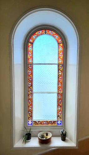 a stained glass window in a room with potted plants at Straven Guesthouse in Edinburgh