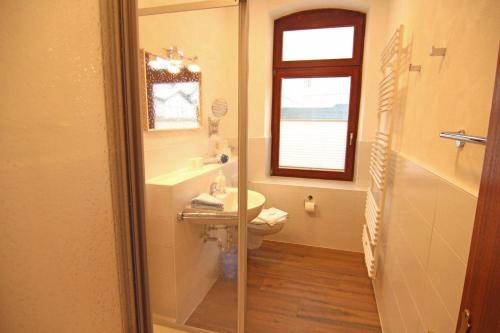 La salle de bains est pourvue d'un lavabo, de toilettes et d'une fenêtre. dans l'établissement Kapitaenshaus-Lassen-Zimmer-Mendoza, à Westerland