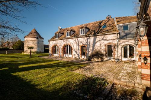 une ancienne maison en pierre avec une cour herbeuse dans l'établissement Magnificent 17th property calm and relaxation, à Bailleau-lʼÉvêque