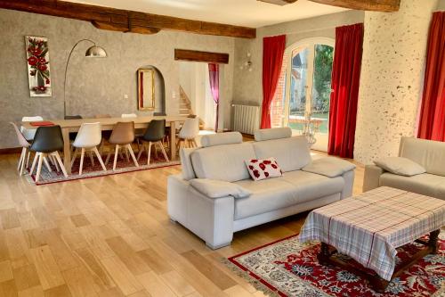 a living room with a white couch and a table at Magnificent 17th property calm and relaxation in Bailleau-lʼÉvêque