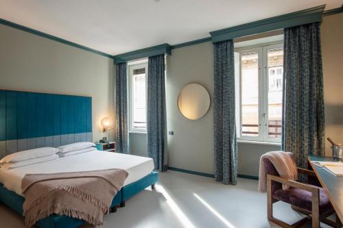 Schlafzimmer mit einem Bett, einem Tisch und Fenstern in der Unterkunft Hotel Milani in Rom
