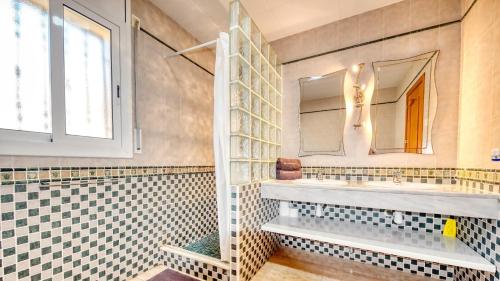 baño con azulejos blancos y negros y espejo en Costacabana - Villa Holiday, en Lloret de Mar