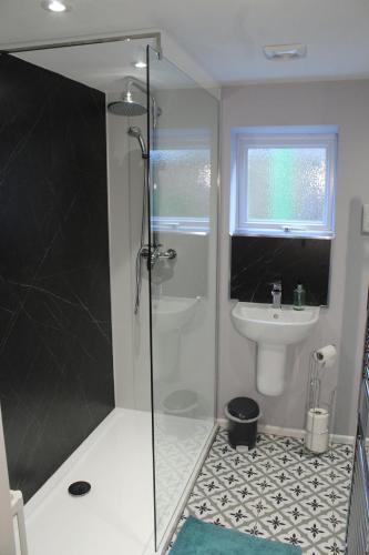 a bathroom with a shower and a sink at Acomb Lodge in Harrogate