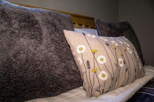 a pillow with flowers on it sitting on a bed at Acomb Lodge in Harrogate