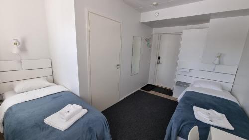 a room with two beds with towels on them at Vanha-Merivartioasema in Kotka