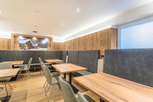 a restaurant with wooden tables and chairs and a large screen at Luisalle Top 2 in Auffach
