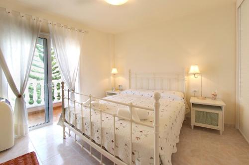 una camera bianca con un letto bianco e una finestra di Lovely 2 bedroom home with nice Pool and View a Costa Del Silencio