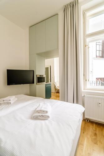 a white bed in a room with a large window at Apartment Brno in Brno