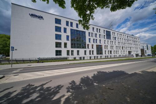 duży biały budynek po stronie ulicy w obiekcie Apartamenty Collegia w Gdańsku