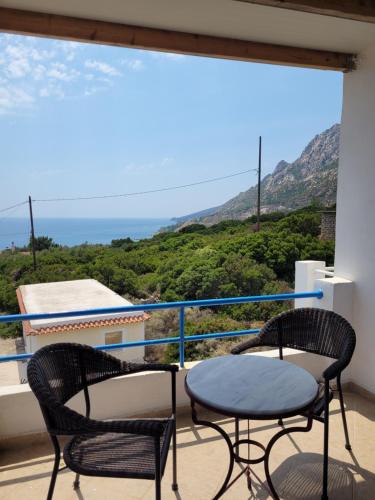 a balcony with two chairs and a table at LEFKADA TWINS 4 in Agios Kirykos