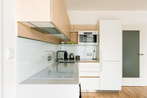 a kitchen with white cabinets and a counter top at Apartment Brno in Brno