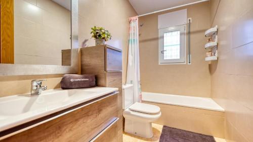 ein Badezimmer mit einem Waschbecken, einem WC und einem Spiegel in der Unterkunft Costacabana - Villa Liliana in Vidreres