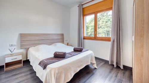 Schlafzimmer mit einem Bett und einem Fenster in der Unterkunft Costacabana - Villa Liliana in Vidreres