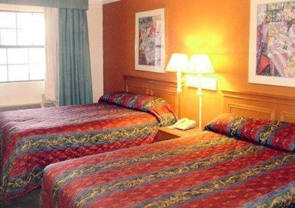 a hotel room with two beds and a phone at SUNSET INN Oklahoma City in Oklahoma City