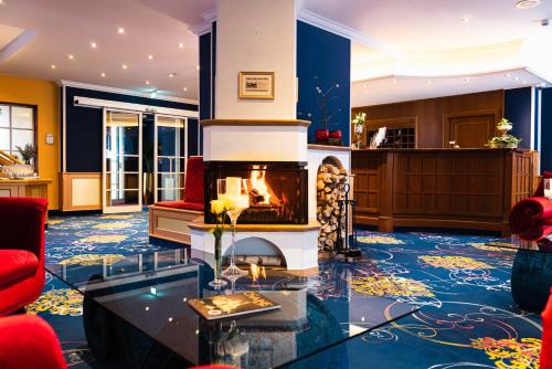 a living room with a fireplace in the middle at Hotel BEI SCHUMANN in Kirschau