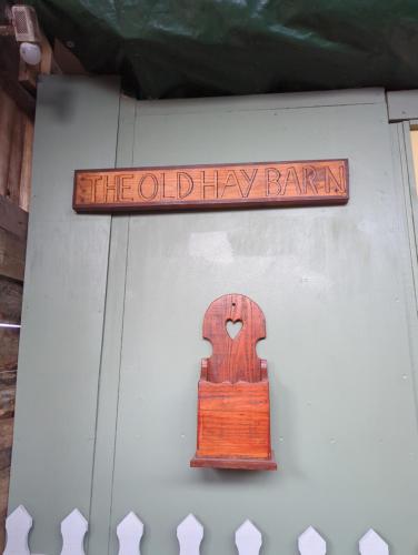 una señal para el antiguo granero de heno con puerta de madera en The Old Hay Barn en Bursledon