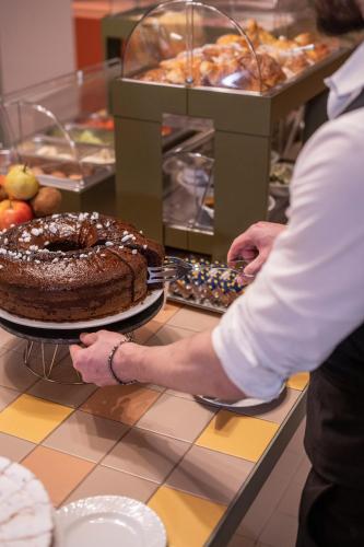 a person holding a chocolate cake on a counter at Hotel Milani in Rome