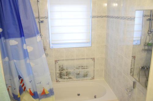 a bathroom with a tub and a shower with a window at 100qm comfort, family-friendly and top located in Guntramsdorf