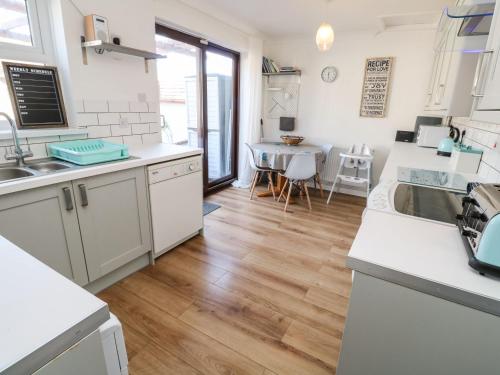 a kitchen with white appliances and a dining room at Seagulls Retreat in Falmouth