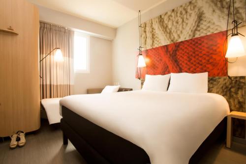 a hotel room with a large white bed and a window at ibis Lima Reducto Miraflores in Lima