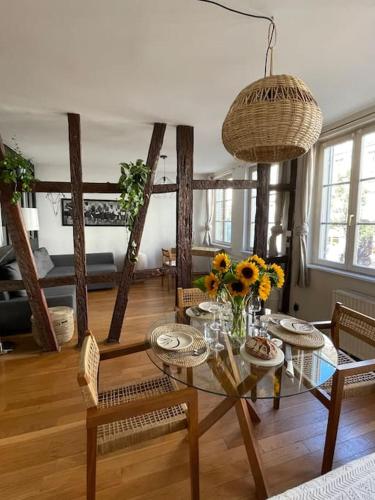 - un salon doté d'une table avec des fleurs et des chaises dans l'établissement Appartement 2 chambres au cœur de Strasbourg, à Strasbourg