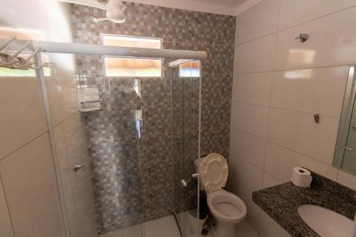 a bathroom with a shower with a toilet and a sink at Pousada Três Praias in Guarapari