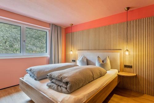 two beds in a bedroom with orange walls at Luisalle Top 6 in Auffach