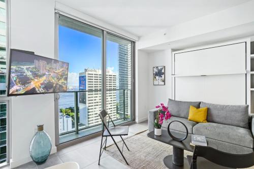 a living room with a couch and large windows at - Casiola Studio's - near Cruise Terminal, Bayfront Park and Kaseya Center in Miami