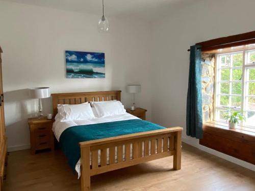a bedroom with a bed and a window at Pembrokeshire Near Beach With A Hot Tub in Pembroke
