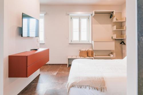 a bedroom with a bed and a dresser at La Tenuta di Santo Stefano Agri Resort & Spa in Fossano