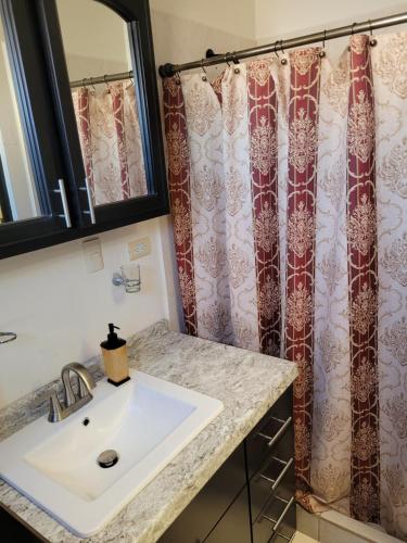 a bathroom with a sink and a shower curtain at Relaxing Place Near the Sea in Ensenada
