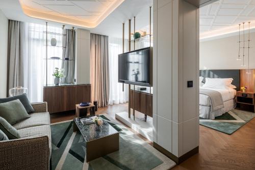 un soggiorno con divano e TV di Casa Baglioni Milan - The Leading Hotels of the World a Milano