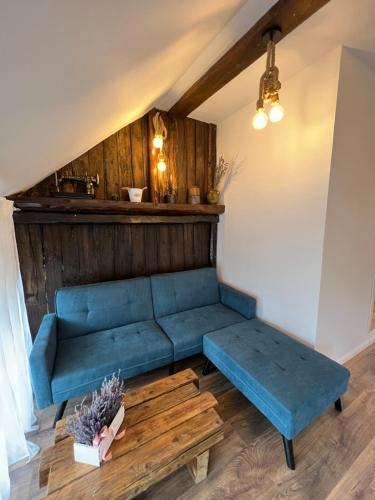 a living room with a blue couch and a table at Casa de vacanta traditionala La Fanar in Schiuleşti