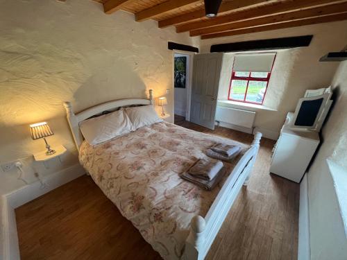 um quarto com uma cama e uma televisão num quarto em Carraun Cottage em Manorhamilton