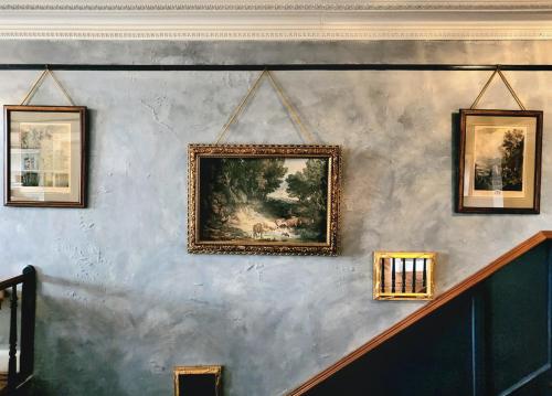 a painting on a wall with four pictures on it at South Court Inn in Luray
