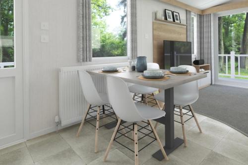a dining room with a table and white chairs at The Springer Van - Beautiful, luxury static caravan in Aberlour