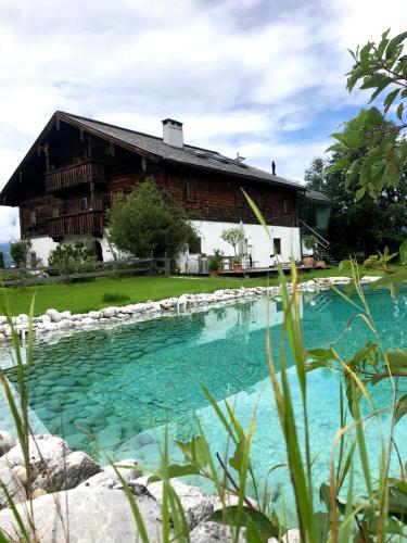 a house with a pool of water in front of it at Kaps Wohnen in Saalfelden am Steinernen Meer