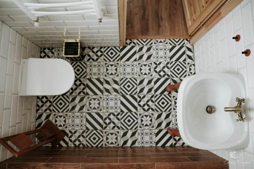 a bathroom with a urinal and a black and white tiles at Zaczarowana Furmanka in Antolka