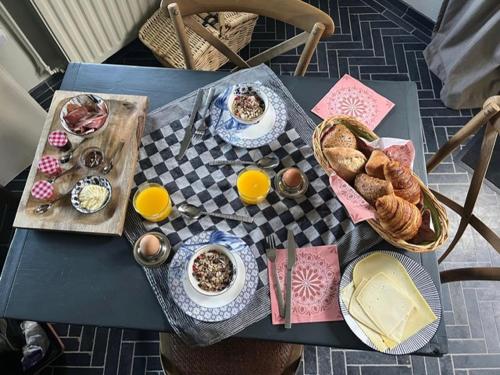 une table avec des assiettes de nourriture et des paniers de pain dans l'établissement B&B De Beijersche Stee , Logies in de Wagenschuur, à Stolwijk